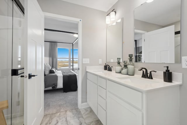 bathroom featuring double vanity, marble finish floor, connected bathroom, and a sink