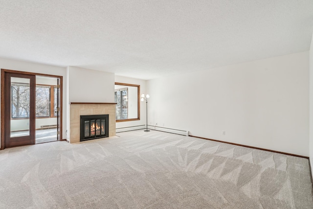 unfurnished living room featuring light colored carpet, a healthy amount of sunlight, a textured ceiling, and a tile fireplace