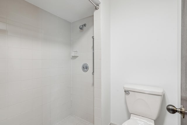 bathroom with toilet and a tile shower