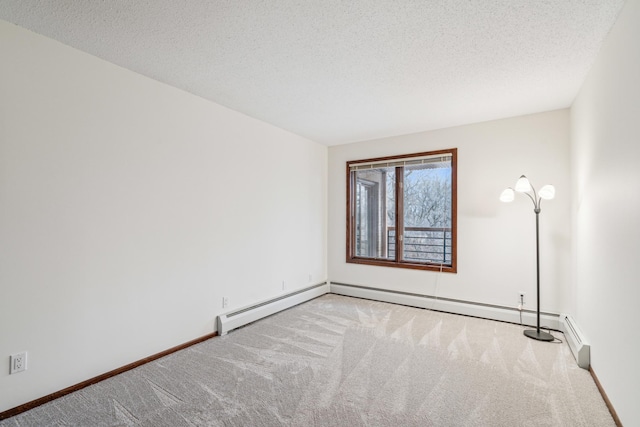 carpeted spare room featuring a textured ceiling and baseboards