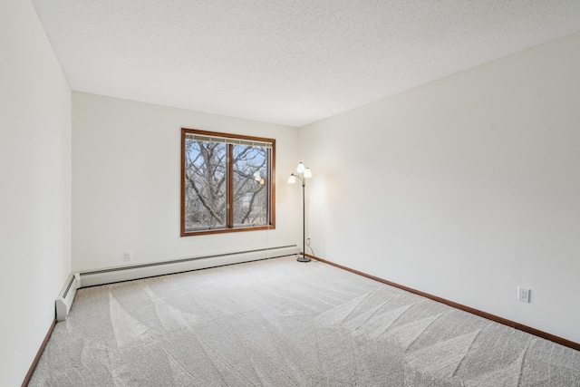 carpeted spare room with a textured ceiling, a baseboard radiator, and baseboards