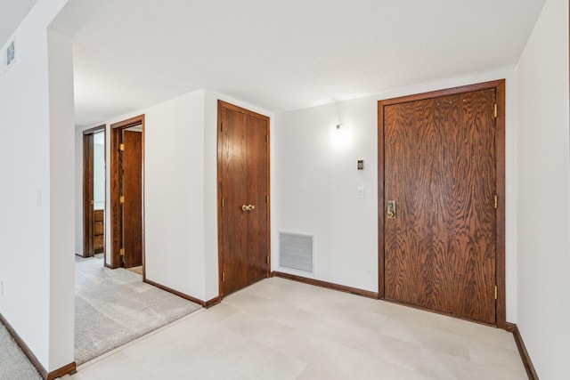 unfurnished bedroom with baseboards, visible vents, and light colored carpet