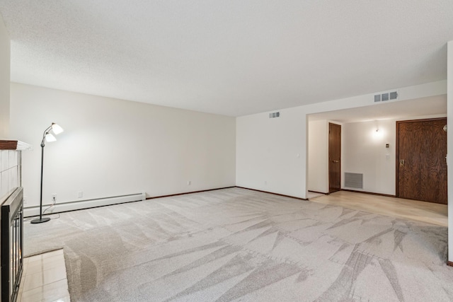 interior space with baseboard heating, a tile fireplace, visible vents, and light colored carpet