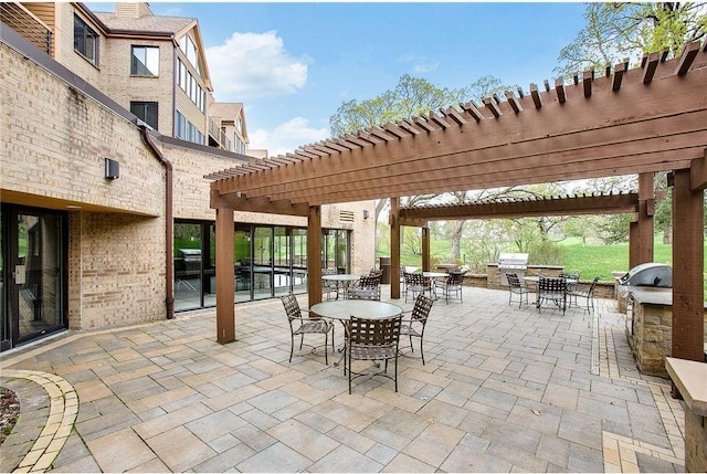 view of patio featuring outdoor dining space, an outdoor kitchen, and a pergola