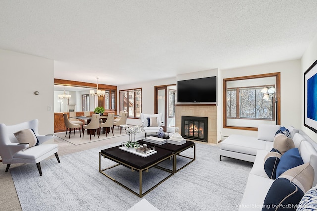 living area featuring plenty of natural light, a notable chandelier, and carpet flooring