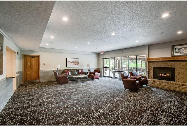 living room with a textured ceiling, recessed lighting, a wainscoted wall, a fireplace, and carpet flooring