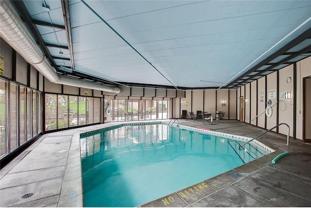 community pool with glass enclosure and a patio area