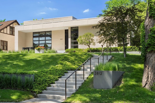 view of front of property with a front yard and stucco siding