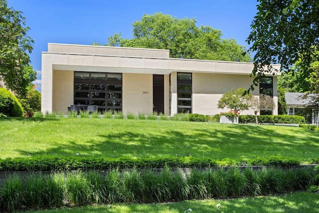 back of property featuring a yard and stucco siding