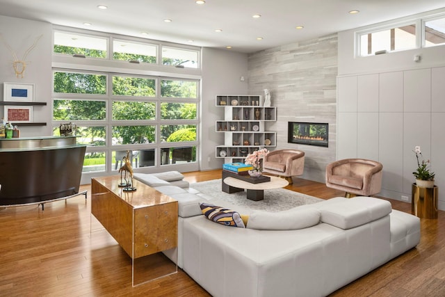 living area with a tiled fireplace, wood finished floors, and recessed lighting