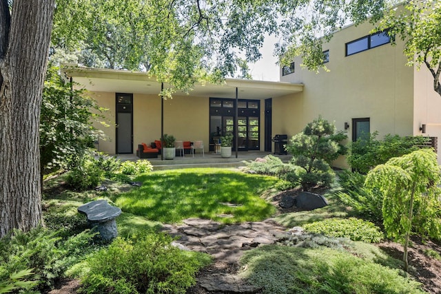 rear view of property featuring stucco siding