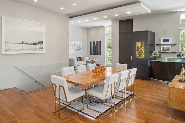 dining room with recessed lighting, a healthy amount of sunlight, and wood finished floors