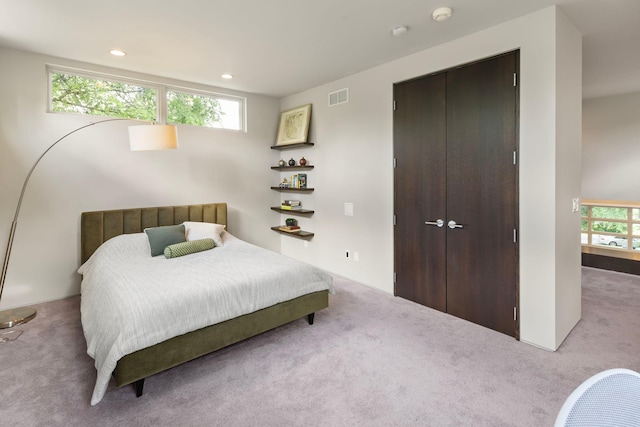 bedroom featuring carpet floors, a closet, visible vents, and multiple windows