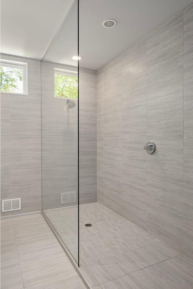 bathroom with a walk in shower and visible vents