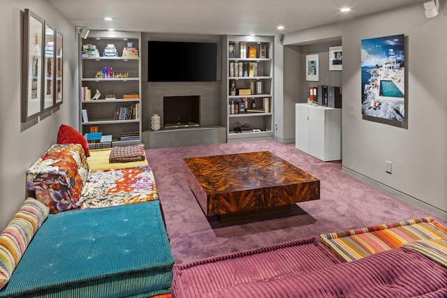 living area featuring carpet, built in shelves, a fireplace with raised hearth, and recessed lighting