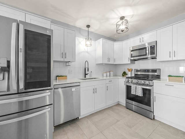 kitchen featuring a sink, appliances with stainless steel finishes, backsplash, and light countertops