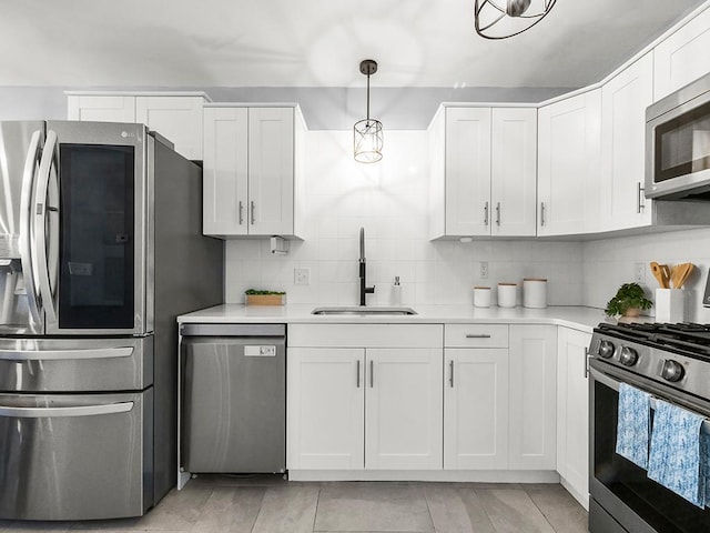 kitchen featuring a sink, appliances with stainless steel finishes, backsplash, and light countertops