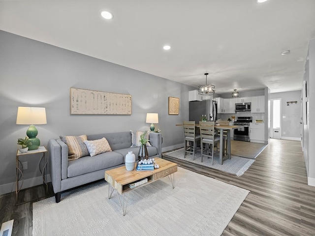 living area with baseboards, recessed lighting, and wood finished floors