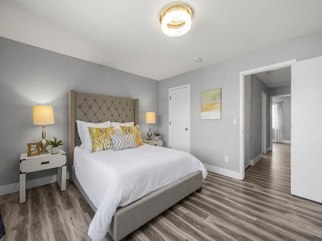 bedroom featuring baseboards and wood finished floors