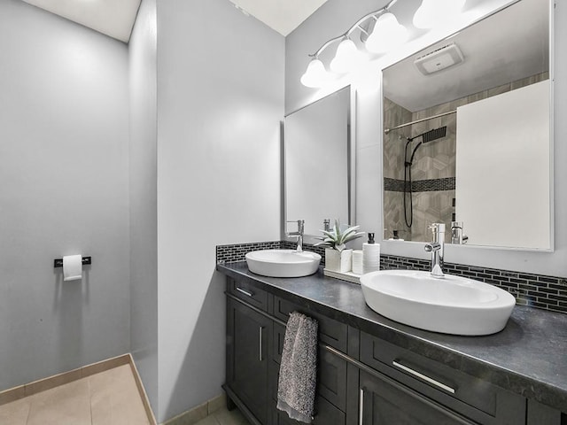 bathroom with double vanity, a sink, tile patterned flooring, and a stall shower