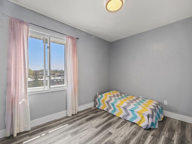bedroom with baseboards and wood finished floors