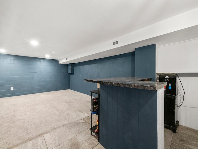 bar with visible vents, a dry bar, and concrete block wall