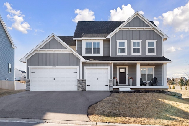 view of front of home featuring aphalt driveway, a shingled roof, a porch, and board and batten siding