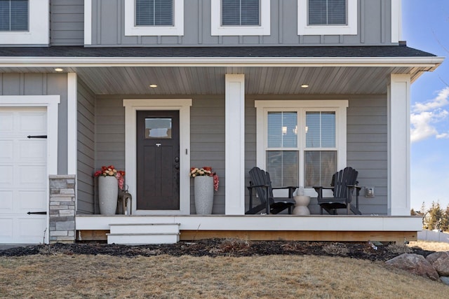 doorway to property featuring a garage, a porch, and board and batten siding