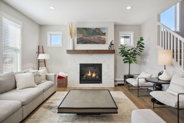 living area featuring recessed lighting, stairs, wood finished floors, and a tiled fireplace