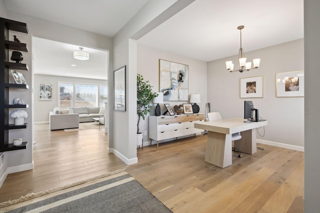 home office featuring a chandelier, light wood-type flooring, and baseboards