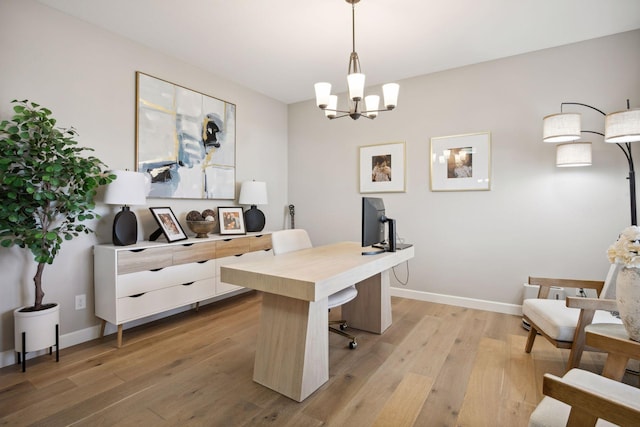 office area featuring a notable chandelier, light wood-type flooring, and baseboards