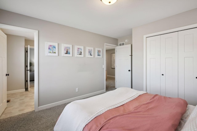 bedroom featuring a closet, light carpet, visible vents, and baseboards