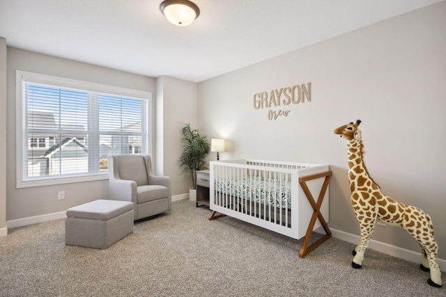 carpeted bedroom featuring a nursery area and baseboards