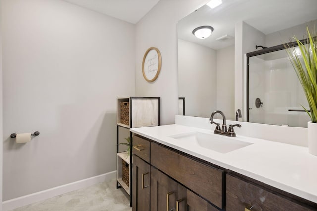 full bath with vanity, baseboards, and walk in shower