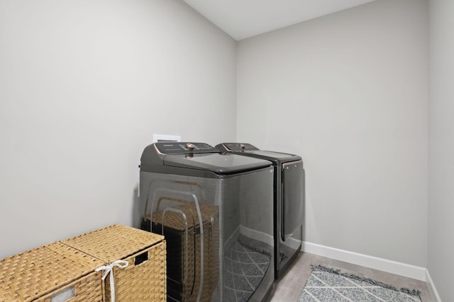 washroom with laundry area, baseboards, and washing machine and clothes dryer