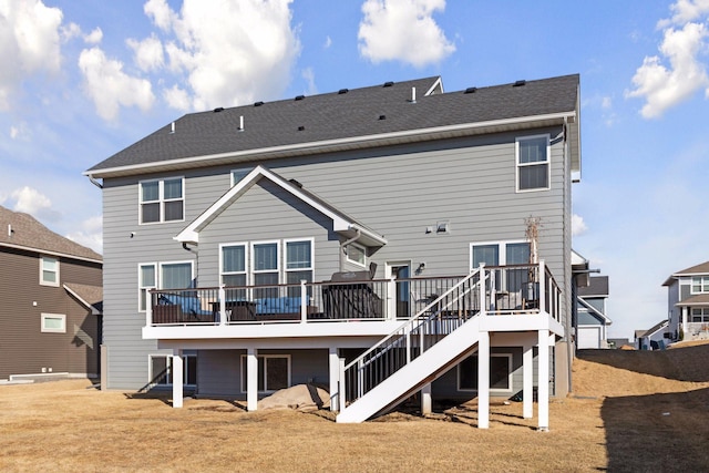 back of house featuring a deck, roof with shingles, and stairway