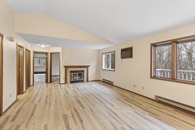 unfurnished living room with a fireplace, a healthy amount of sunlight, vaulted ceiling, an AC wall unit, and baseboard heating