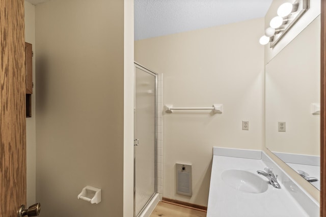 bathroom featuring visible vents, a shower stall, vanity, and a textured ceiling