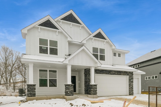 view of front facade featuring a garage, stone siding, and board and batten siding