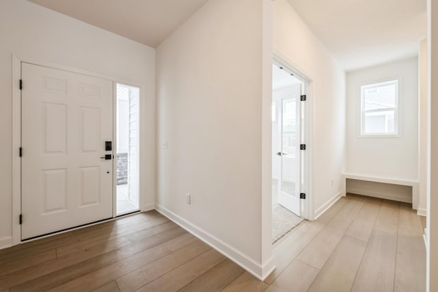 foyer featuring light wood finished floors and baseboards