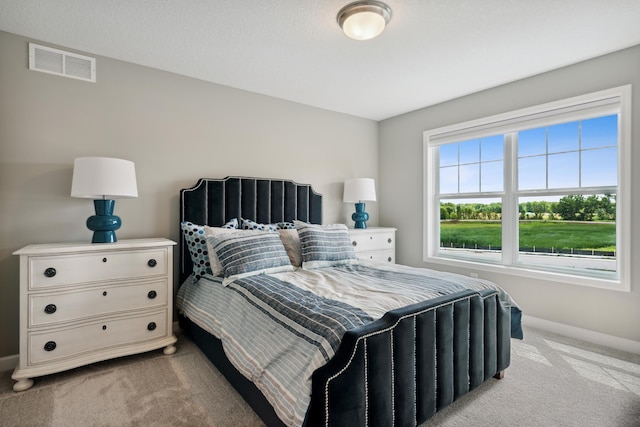 bedroom featuring light carpet, visible vents, and baseboards