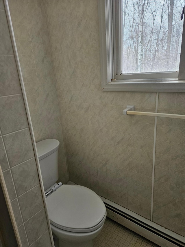 bathroom featuring tile walls, toilet, and baseboard heating