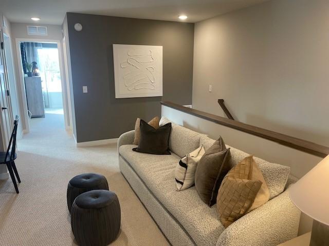 living area with carpet floors, recessed lighting, visible vents, and baseboards