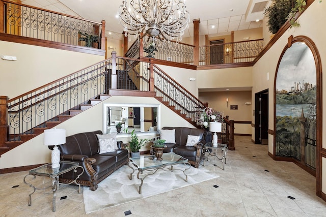 living room featuring stairs, a high ceiling, baseboards, and a chandelier