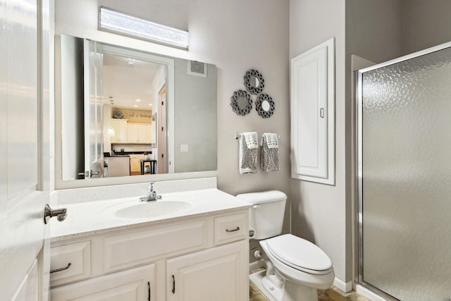 full bathroom featuring a shower stall, toilet, and vanity