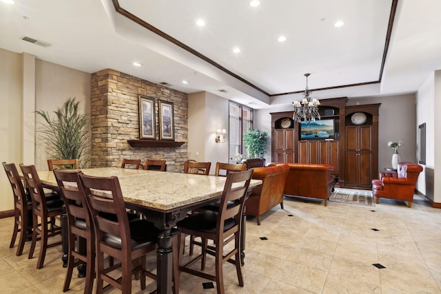 dining area with a chandelier, visible vents, baseboards, and a tray ceiling