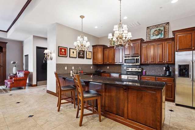 kitchen with backsplash, a breakfast bar, dark stone countertops, appliances with stainless steel finishes, and a sink