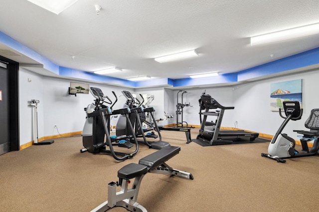 exercise room with baseboards and a textured ceiling