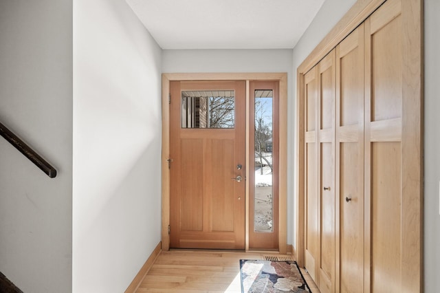 foyer with light wood finished floors and baseboards