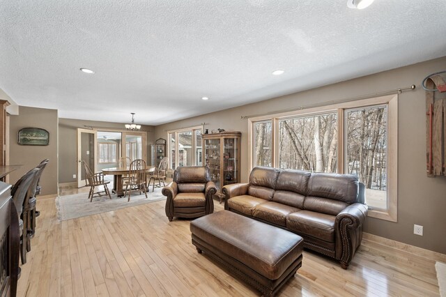 living area featuring plenty of natural light, light wood-style floors, and a textured ceiling